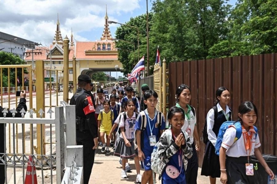 Thai military personnel stand guard as Cambodian students cross the closed Ban Khlong Luek border checkpoint in Aranyaprathet on June 24, 2025. 